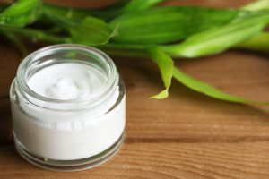 Face cream with bamboo on wooden background