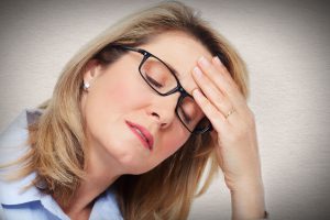 Woman with a headache rubbing her forehead