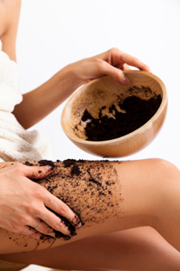 Woman rubbing coffee grounds on her thighs